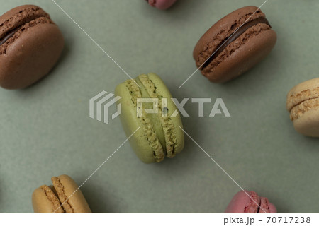 Colored tasty macaroons over a green background. 70717238
