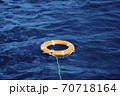 An Orange Lifebuoy Floating in the Middle of the Ocean 70718164