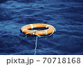 An Orange Lifebuoy Floating in the Middle of the Ocean 70718168