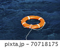An Orange Lifebuoy Floating in the Middle of the Ocean 70718175