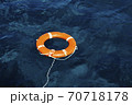 An Orange Lifebuoy Floating in the Middle of the Ocean 70718178