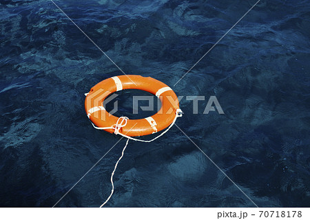 An Orange Lifebuoy Floating in the Middle of the Ocean An Orange Lifebuoy Floating in the Middle of the Ocean 70718178