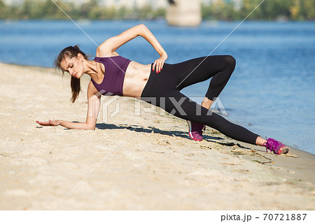 Young woman training outdoors in autumn sunshine. Concept of sport, healthy lifestyle, movement, activity. Young woman training outdoors in autumn sunshine. Concept of sport, healthy lifestyle, movement, activity. 70721887