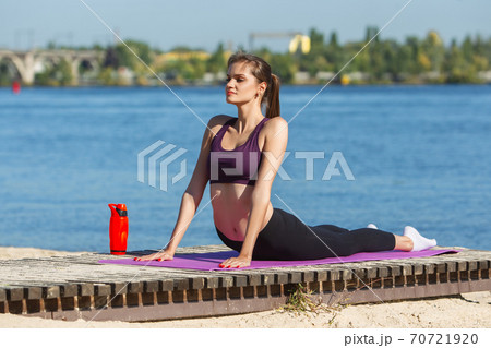 Young woman training outdoors in autumn sunshine. Concept of sport, healthy lifestyle, movement, activity. Young woman training outdoors in autumn sunshine. Concept of sport, healthy lifestyle, movement, activity. 70721920
