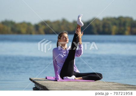 Young woman training outdoors in autumn sunshine. Concept of sport, healthy lifestyle, movement, activity. 70721958