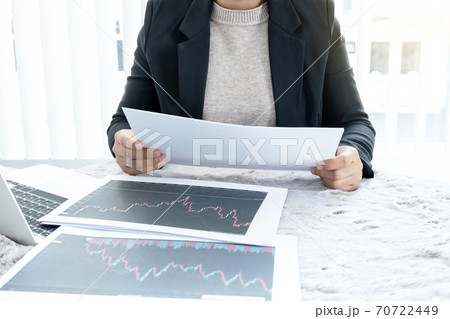The hands of a female business brokerage are planning business investments by analyzing and calculating the stock market to find market profits 70722449