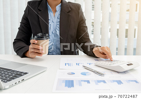 The hands of a male businesswoman use the calculator are analyzing and calculating the annual income and expenses in a financial graph that shows results To summarize balances overall in office The hands of a male businesswoman use the calculator are analyzing and calculating the annual income and expenses in a financial graph that shows results To summarize balances overall in office 70722487