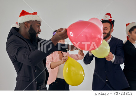The business people in santa hat playing with balloons 70723815