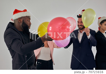 The business people in santa hat playing with balloons 70723816