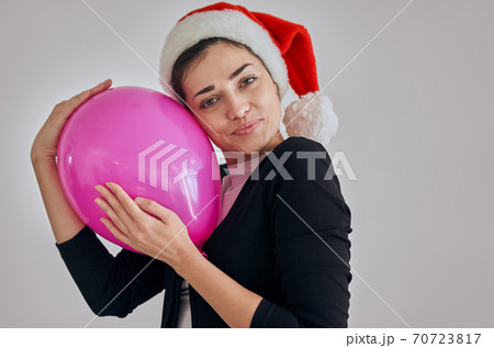 The happy woman in santa hat holding the balloon The happy woman in santa hat holding the balloon 70723817