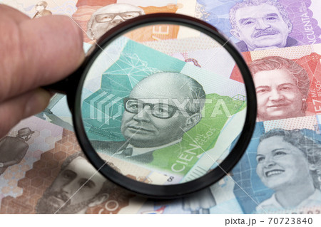 Colombian peso in a magnifying glass Colombian peso in a magnifying glass 70723840