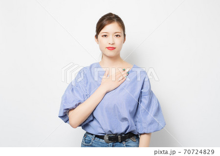 胸に手を当てる若い女性 70724829