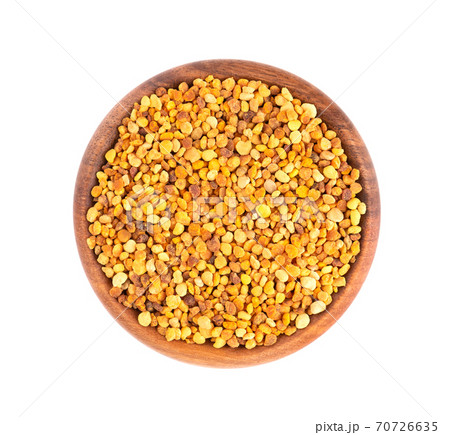 Flower pollen grains in wooden bowl, isolated on white background. Pile of bee pollen or perga. Top view. Flower pollen grains in wooden bowl, isolated on white background. Pile of bee pollen or perga. Top view. 70726635