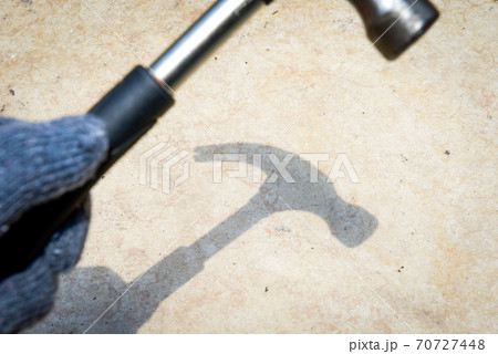 Hand with glove holding hammer Hand with glove holding hammer 70727448
