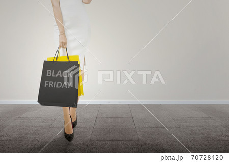 Women carrying a shopping bag with a white wall background 70728420