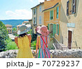 南仏のカラフルな町で景色を眺める帽子を被った女性2人 70729237