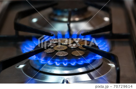 coins lie on the stove burner on which the gas is turned on coins lie on the stove burner on which the gas is turned on 70729614