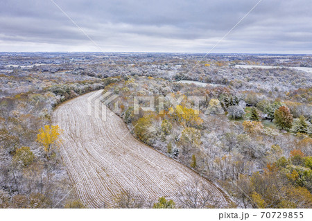 Forest and corn field dusted by early snow 70729855