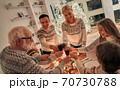 The happy family clink glasses above the christmas table 70730788