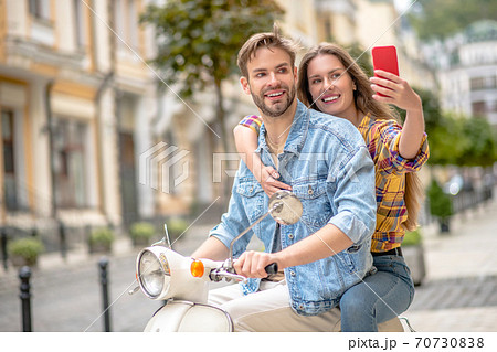 Woman hugging a man and taking a selfie Woman hugging a man and taking a selfie 70730838