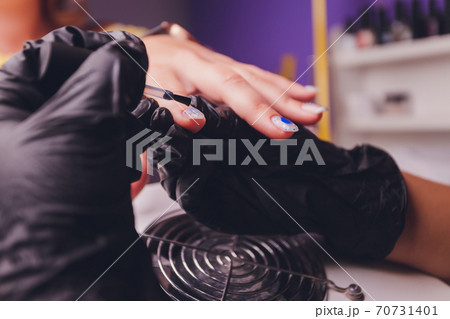 woman doing manicure in a beauty salon. Close-up of hands. 70731401