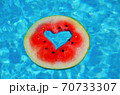 A heart shaped watermelon, floating in the blue waters of the Mediterranean Sea.  70733307