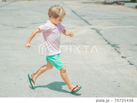 Smiling freckled blond boy autistic facial expressions, run marching hands gestures, mischievous in good mood, summer flip flops sandal. Funny photo, happiness lifestyle simple joys childhood children Smiling freckled blond boy autistic facial expressions, run marching hands gestures, mischievous in good mood, summer flip flops sandal. Funny photo, happiness lifestyle simple joys childhood children 70735436