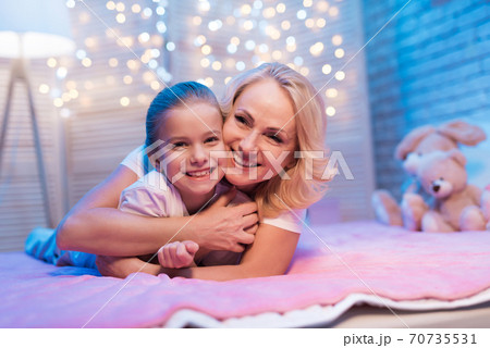 Grandmother and granddaughter are hugging. 70735531