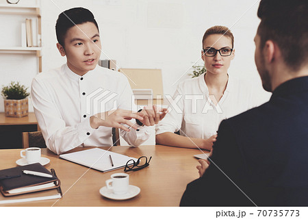 A man sits at table and communicates with managers A man sits at table and communicates with managers 70735773