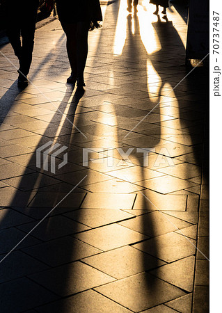 Long human shadows projected on the pavement at sunset Long human shadows projected on the pavement at sunset 70737487