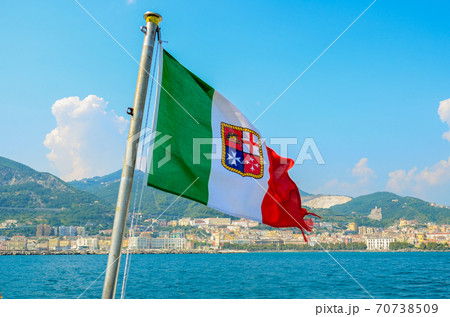 Civil ensign of Italy. National Flag on the background of the sea and mountains Civil ensign of Italy. National Flag on the background of the sea and mountains 70738509