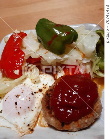 ハンバーグと目玉焼きと野菜のソテーのおかずの写真素材