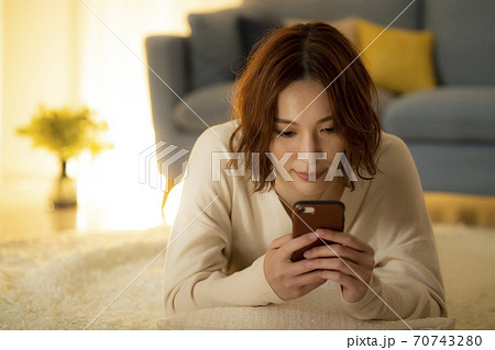 夜のリビングでスマホを見る女性 夜のリビングでスマホを見る女性 70743280