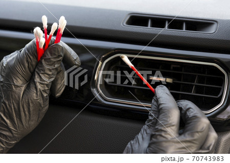 Worker cleaning automobile air conditioner vent grill with brush, closeup. Car wash service 70743983