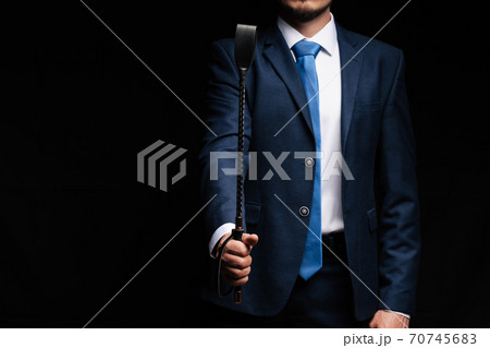 male dominant holds a leather whip Flogger for hard BDSM sex male dominant holds a leather whip Flogger for hard BDSM sex 70745683