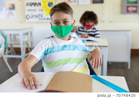 Portrait of boy wearing face mask sitting in class at school 70748420