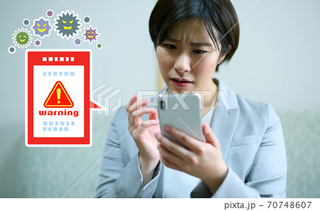 スマホがウイルスに感染して困る女性会社員のイメージ 70748607