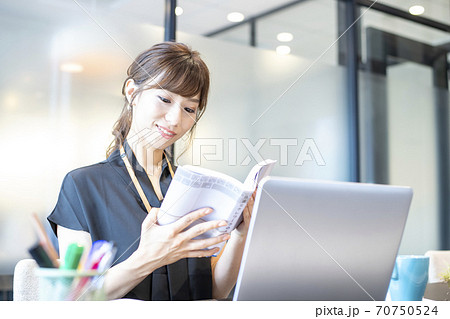 テレワーク関係の書籍を参考に初めてのテレワークにチャレンジしているビジネスパーソン テレワーク関係の書籍を参考に初めてのテレワークにチャレンジしているビジネスパーソン 70750524