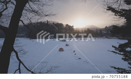 日の出を待つ 氷結した松原湖のワカサギの穴釣りテント群 70755188