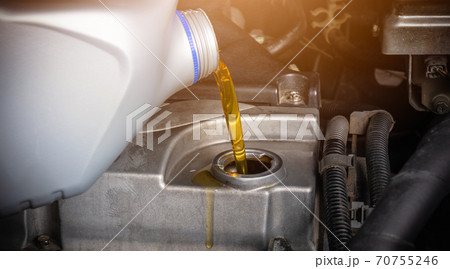 Hand mechanic in service to repair a car, pouring change lubricant oil 70755246
