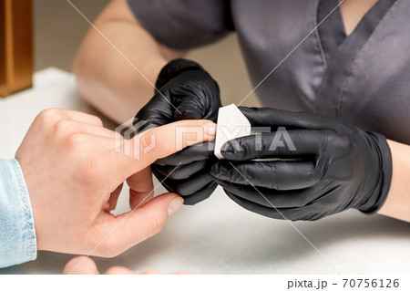 Manicurist doing manicure by nail file Manicurist doing manicure by nail file 70756126