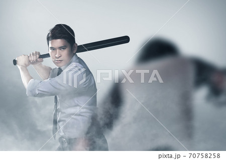Asian man standing with a baseball bat in his hand ready to attack zombies 70758258