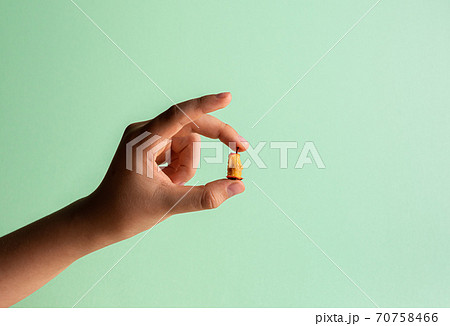 Hand with small haw stump in fingers on green Hand with small haw stump in fingers on green 70758466