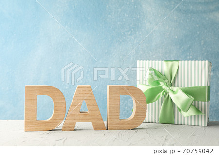 Gift box with green ribbon and inscription DAD on white table ag Gift box with green ribbon and inscription DAD on white table ag 70759042