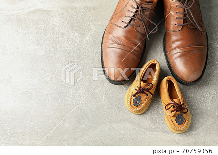 Brown leather shoes and children's shoes on grey background 70759056