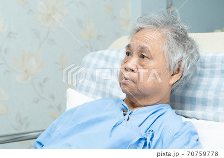 Asian senior or elderly old lady woman patient sitting and worry covid-19 on bed in nursing hospital ward 70759778