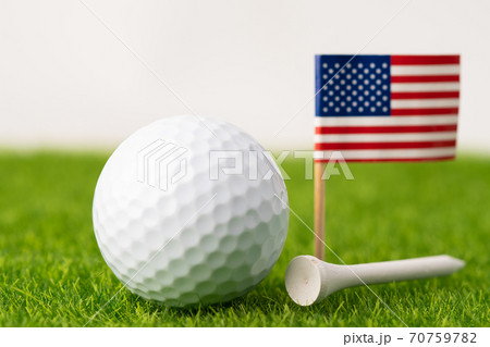 Golf ball with USA flag and tee on green lawn or grass is most popular sport in the world. Golf ball with USA flag and tee on green lawn or grass is most popular sport in the world. 70759782