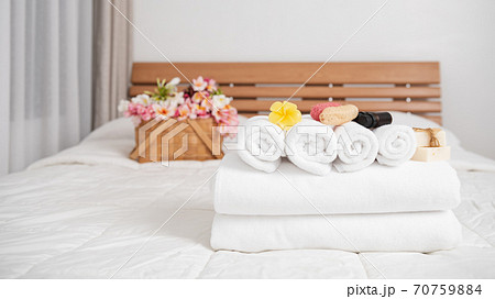 Spa wellness concept with white towels,candle,milk soap,beautiful frangipani flowers in bamboo wooden basket on modern white bedroom Spa wellness concept with white towels,candle,milk soap,beautiful frangipani flowers in bamboo wooden basket on modern white bedroom 70759884