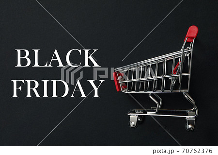 Shop trolley on black background, space for text 70762376