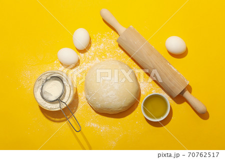Concept for baking with dough on yellow background 70762517